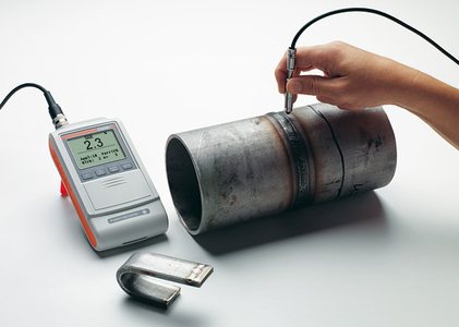 Portable hardness tester measuring a pipe section